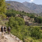 Travelers walking toward a mountain village in Morocco’s High Atlas